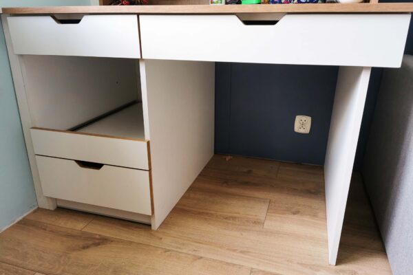 białe biurko z drewnianymi dodatkami w pokoju dziecięcym